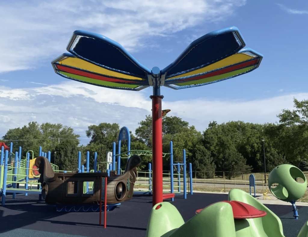 Colorful playground equipment and a large butterfly structure at All My Friends Playground in Grafton.